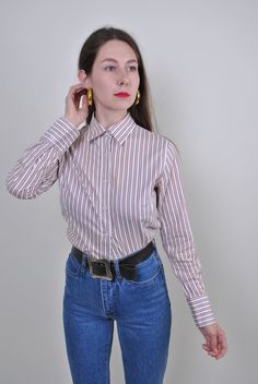 "White striped shirt, vintage formal blouse, Size M Welcome to TARASCOMMON.ETSY.COM Unique clothing from the 20th century. Model tall 170cm. Size: M. Sleeve - 60cm / 23.62inch; Width - 40cm / 15.74inch; Length - 67cm / 26.37inch. COTTON. All measurements are taken seam to seam while lying flat. This item is vintage, so it can have some defects. Additional photos can be send! We are glad that you are interested in lots that we sell. Wish you a good shopping! FOLLOW US : Instagram:https://www.inst Classic Vertical Stripes Blouse For Fall, Classic Formal Blouse With Striped Collar, Classic Pinstripe Blouse With Striped Collar, Classic Long Sleeve Blouse With Vertical Stripes, Retro Button-up Formal Shirt, Vintage Fitted Formal Shirt, Classic Striped Blouse For Formal Occasions, Vintage Style Fitted Shirt For Formal Occasions, Vintage Fitted Shirt For Workwear