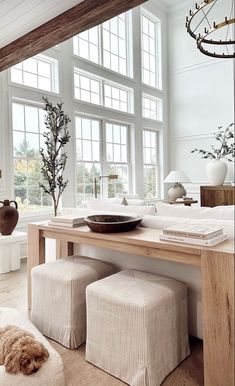 a living room filled with furniture and lots of window sill space next to a wooden table