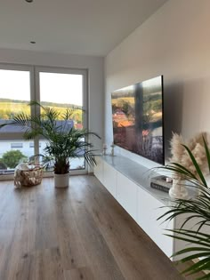 a living room filled with furniture and a large flat screen tv mounted on the wall