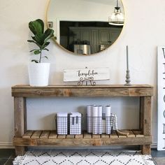 a wooden table sitting next to a mirror on top of a wall