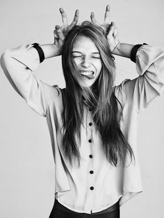 black and white photograph of a woman holding her hands up to her head with both hands