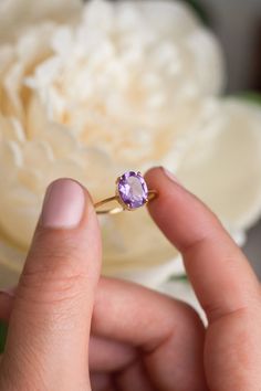 How can something so simple as an oval Amethyst solitaire ring, be so beautiful, you ask? The answer is in the gemstone itself. With a gorgeous vivid purple color, this ring just pops out on your finger and dazzles everyone. To turn it up a notch, add complimentary stacking rings, to create a one-of-a-kind ring set - something extra special for yourself or your loved one. Details: Center gemstone: Amethyst Stone Shape: Oval Measurements: approx. 9x7 mm Weight: approx 1.75 ct Band measurements: a Classic Oval Purple Birthstone Ring, Elegant Purple Oval Birthstone Ring, Purple Oval Birthstone Ring, Oval Amethyst Birthstone Ring Fine Jewelry, Oval Purple Solitaire Birthstone Ring, Lavender Amethyst Ring With Oval Shape, Oval Solitaire Amethyst Ring Gift, Oval Solitaire Amethyst Promise Ring, Oval Lavender Rings For Promise