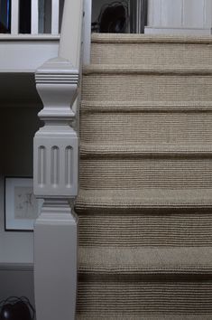 an image of a stair case with carpet on the bottom and second hander in the background