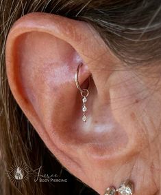 a woman's ear is shown with three small beads