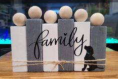 a wooden block with some balls on top of it and the word family written in black