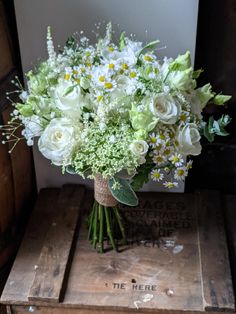 a bouquet of white flowers sitting on top of a wooden box