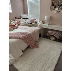 a bedroom with teddy bears on the bed and rugs in front of the window