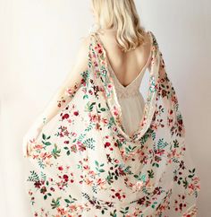 a woman with blonde hair wearing a white floral print shawl over her shoulders and back