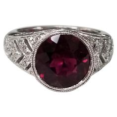 14k white gold garnet and diamond ring, containing 1 round garnet of gem quality weighing 2.98cts. and 38 round full cut diamonds weighing .45pts. This ring is a size 5.5 but we will size to fit for free. Daimond Rings, Garnet Wedding Rings, Garnet Wedding, Yellow Gold Cocktail Ring, Garnet And Diamond Ring, Contemporary Jewelry Design, Garnet And Gold, Ruby Diamond Rings, Platinum Diamond Rings