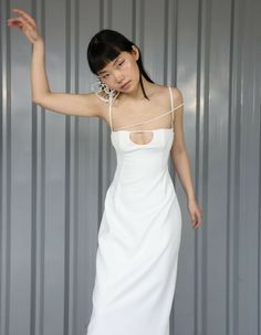 a woman in a white dress posing for the camera