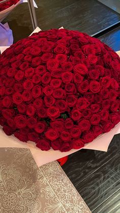 a large bouquet of red roses sitting on top of a table