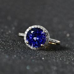 Item Details- Metal- 10K Solid Yellow Gold Stone- Natural Tanzanite Shape- Oval 8x8mm Total Weight- 2.20 Ct. Approx. Accent Stone- Moissanite Shape-Round Cut 1.3mm   Setting- Prong Fit- Comfort DESCRIPTION: The stones used in the Jewelry are 100% Natural with Earth Origin. You'll get Jewelry like the ones in the picture per purchase. ( Although, you can update more quantity according to the need. ) We accept custom and personalized order. It can be change in the gemstone, design and size. Please Timeless Tanzanite Diamond Ring, Yellow Gold Tanzanite Diamond Ring With Halo Setting, Tanzanite Rings With Halo Setting, Tanzanite Diamond Ring With Halo Setting, Sapphire Round Halo Ring, Round Tanzanite Diamond Ring With Accent Stones, Yellow Gold Halo Ring With Accent Stones, Round Cut Tanzanite Jewelry With Halo, Tanzanite Jewelry