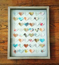 a shadow box filled with lots of different heart shaped magnets on top of a wooden table