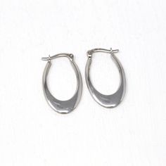 Trendy modern circa 2000's era estate 14k white gold hoop earrings! This classic oval style pair are free of design, and secure with latch back earring closures. These elongated hoops are comfortably lightweight due to their hollow construction, and have a modern style. A fashionable pair of fine jewelry, that is ready to be worn!  ERA - Circa 2000's - Modern   METAL / MATERIAL - 14k white gold   MARKINGS / HISTORY - Earrings are marked "14k Turkey" CONDITION - Good condition. White gold metal has been professionally polished & cleaned. Amazing modern hoop earrings!  MEASUREMENTS - Earrings: 1 inch in length by 15 mm, Weight (both earrings): 1.52 grams PRESENTATION - Listing includes a complimentary MJV logo gift box, as shown in last photo. All other boxes are for display only. AUTHENTICI Modern Hoop Earrings, White Gold Hoop Earrings, White Gold Hoops, Y2k Jewelry, Logo Gifts, Back Light, Shiny Things, Light Weight Earrings, Metal Material