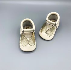 "-Made with 1st grade, 100% genuine calf leather -Handcrafted from start to finish -Angel moccasins are ready to ship for size 12-18 months and will be shipped in 1-2 business days. Made-to-order option is available for other sizes.  -Breathable, soft leather insole -Easy to put on and take off with soft elastic band around ankle -Promotes healthy foot development with four-layered special designed sole; the sole is thick enough for protection while allowing the foot to move naturally.   -Anti-slip sole helps protect your child from slipping -Lightweight, flexible, comfortable, soft and bend easily -Please measure child's foot from heel to big toe before ordering to select the correct size. Add 1/2\" to measurement to get correct sole length. -Leather bow headband sold separately. -If you White Closed Toe Leather Shoes With Leather Sole, White Leather Closed Toe Shoes With Leather Sole, White Leather Shoes With Leather Sole, White Closed Toe Moccasins With Rubber Sole, Leather Booties With Soft Sole For Gift, Leather Booties With Soft Sole As Gift, Gift Leather Booties With Soft Sole, White Soft Sole Booties For First Birthday, Handmade White Closed Toe Booties