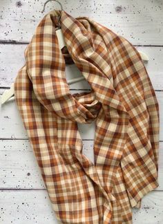 A lovely lightweight scarf in a beige and brown tartan design.  Wear with lightweight knits to carry your wardrobe from autumn/winter right through to spring and beyond.  Machine washable  Measures 69cm x 146cm. Brown Tartan, Check Scarf, Tartan Design, Checked Scarf, Lightweight Scarf, Brown Plaid, Beige Brown, Scarf Wrap, Tartan