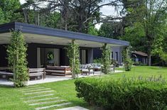 an outdoor dining area in the middle of a lawn with chairs and tables on it