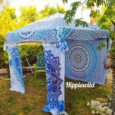 a blue and white gazebo sitting on top of a lush green field