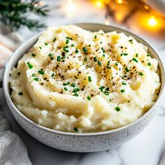 a bowl filled with mashed potatoes and sprinkled with seasoning on top