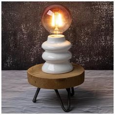 a light bulb sitting on top of a wooden stand