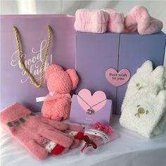 pink and white teddy bears, mittens, card and other items on a table