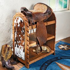 an old wooden shoe rack with cowboy boots and saddles on the floor next to it