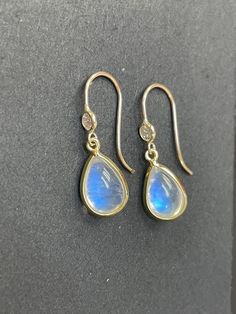 "Natural Blue Moonstone and Diamond 14K Yellow Gold Drop Earrings The diamonds are .06 carats each, VS with F color. The moonstones are each approximately 2 carats, with a double sided cabochon cut. 1.5\" long from top to bottom Made in solid 14K yellow gold. Custom orders welcome!" Moon Stone Earrings, Teardrop Moonstone Earrings With Gemstone Accents, Elegant Pear-shaped Moonstone Jewelry, Elegant Moonstone Earrings With Gemstone Accents, Formal Round Moonstone Earrings, Elegant Blue Moonstone Earrings, Round Moonstone Yellow Gold Earrings, Moonstone Round Yellow Gold Earrings, Moonstone Yellow Gold Round Earrings