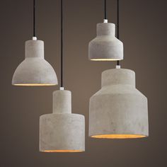 three cement pendant lights hanging from a ceiling