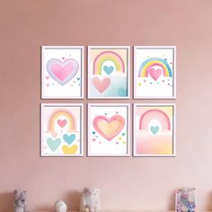 four framed hearts and rainbows are on the wall in this child's room