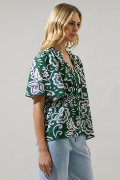 Add a pop of green into your off-duty wardrobe with this Harriet Floral Ruffle Split Neck Dupont Top. A split neckline with short flouncy sleeves adorns this top. The relaxed fit gives it a pretty look, and it can be tied at the neck and tucked into high waisted linen pants top finish off. - Split neck- Tie neck- Ruffle trim- Puffed short sleeves- Color: Cream GreenSize + Fit - Model is 5'8" and wearing size XS- Measurements taken from size S - Chest: 19 1/2"- Length: 25" Fabric Self: 98% Polyes Flouncy Sleeves, High Waisted Linen Pants, Athleisure Accessories, Floral Ruffle Top, Maxi Jumpsuit, Hemant And Nandita, One Shoulder Jumpsuit, Floral Ruffle, Neck Ruffle