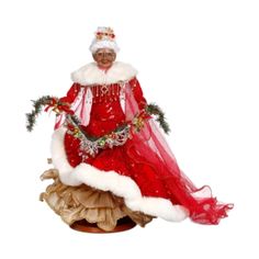 a figurine of a woman dressed in red and white sitting on top of a table