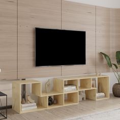 a flat screen tv mounted to the side of a wooden wall in a living room