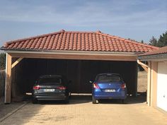 two cars parked in front of a garage with an attached carport and tiled roof