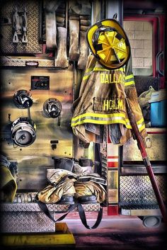 a fireman's uniform is hanging on the wall next to other tools and equipment