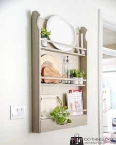 an open book shelf with plants and plates on it