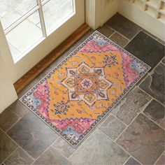 an orange and pink rug sitting on top of a floor next to a door way