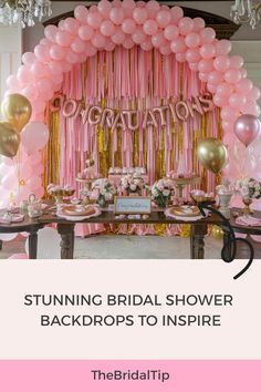 a pink and gold bridal shower backdrop with balloons, streamers, and flowers