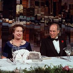 two people sitting at a table with wine glasses and silverware in front of them