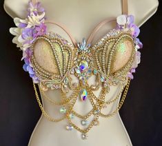 a bra that is adorned with jewels and flowers on top of a mannequin