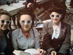 three women sitting next to each other wearing sunglasses