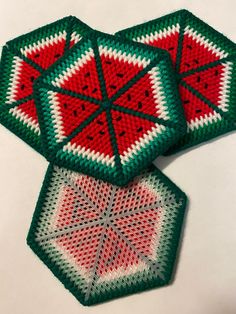 two crocheted coasters sitting next to each other on top of a table