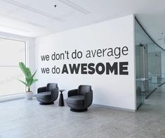 an office lobby with two chairs and a wall that says we don't do average, we do awesome