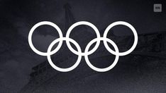 an olympic symbol is shown in front of the eiffel tower on a dark background