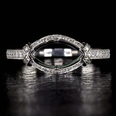 an art deco style diamond ring on a black background