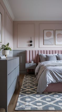 a bedroom with pink walls and grey furniture, including a bed that has a headboard on it