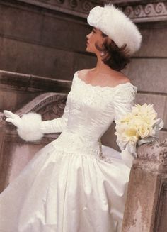 a woman in a white wedding dress and hat