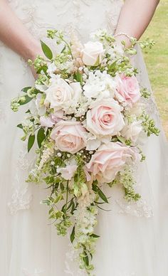 a bridal holding a bouquet of white and pink flowers