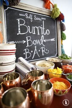 the buffet table is set up with bowls, cups and other food items on it