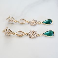 "These long emerald green gold art deco earrings feature a fan shaped posts followed by peach glass crystals and green teardrop stones. A gorgeous statement earrings perfect for bride, bridal shower, wedding guest earrings or any formal party event. They exude vintage sophistication and glamour and will transport you to the glitz and glam of a 1920s soiree. Materials : glass crystals with gold plated setting, gold vermeil ear posts DIMENSION: ------------------- Earrings : ~2.25 inches long x 3/ Green Art Deco Drop Earrings, Art Deco Green Jewelry For Pierced Ears, Art Deco Gold Jewelry With Emerald, Art Deco Emerald Jewelry In Gold, Green Chandelier Earrings For Anniversary, Art Deco Gold Emerald Jewelry, Green Dangle Chandelier Earrings For Anniversary, Emerald Drop Earrings For Anniversary, Green Dangle Clip-on Earrings For Wedding