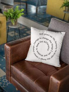 a brown leather chair with a white pillow on it and a plant in the background